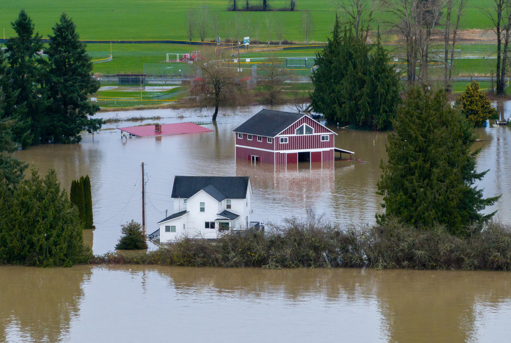 Houses and a red barn standing in floodwater in Panama City, FL